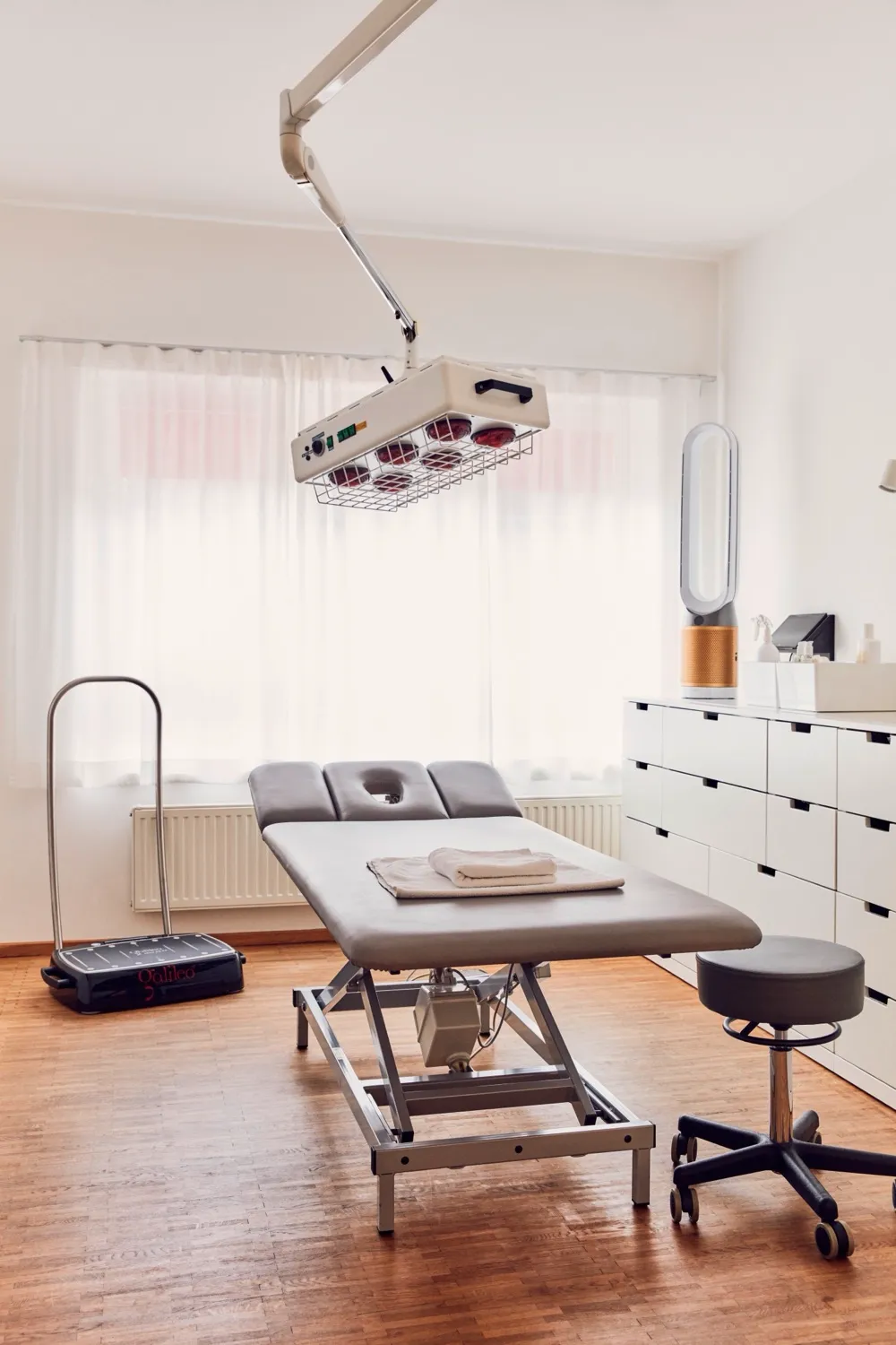 Behandlungsraum mit Therapieliege und Wärmelampe
