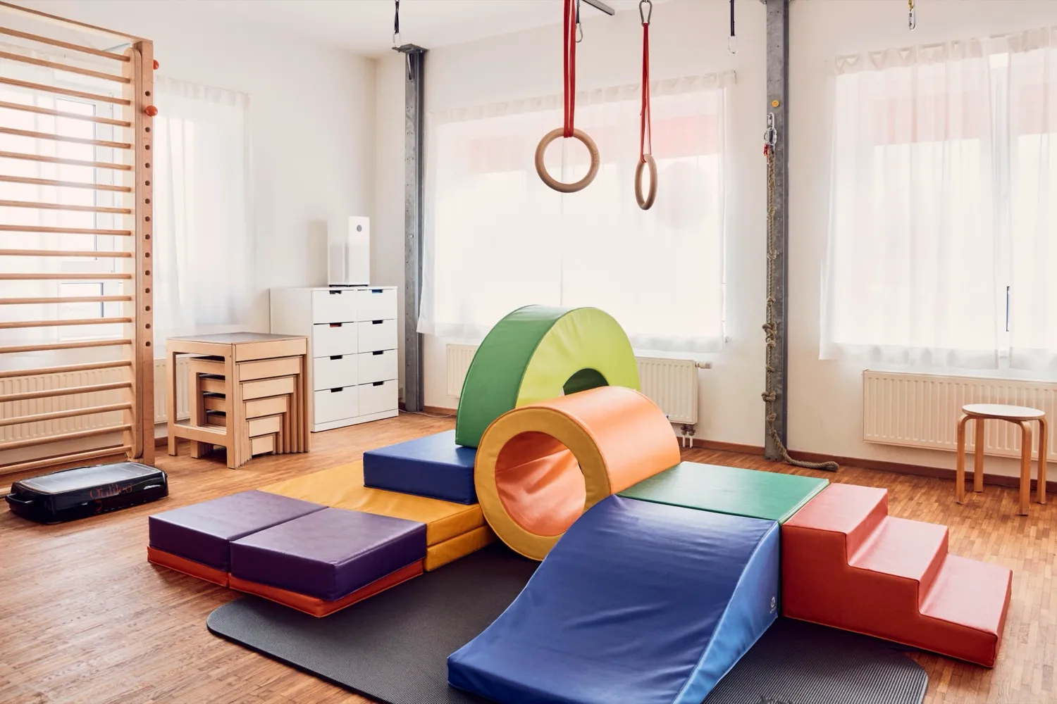 Therapieraum mit bunten Bewegungselementen für Kinder